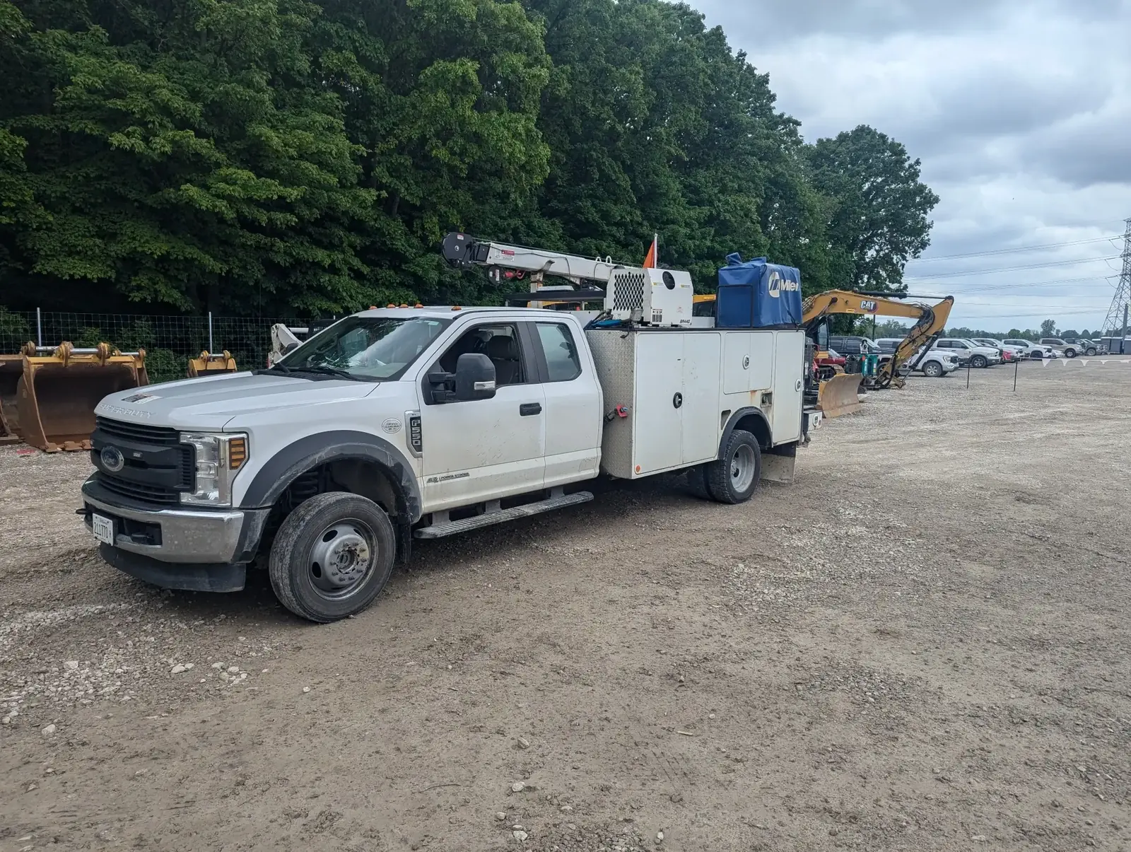 Ford F-550 mobile service truck with boom crane and Miller welder set up for on-site heavy equipment repair